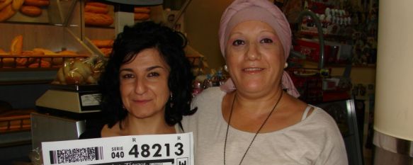 María del Mar González y Marisol Mariscal, trabajadora y propietaria respectivamente de Panadería y Pastelería Nazaret, muestran una fotocopia del cupón premiado. // CharryTV