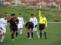 El colegiado sevillano Moreno Díaz muestra la cartulina amarilla a un jugador visitante. // CharryTV
