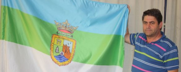 Un vecino muestra la bandera y el escudo de Montecorto. // CharryTV