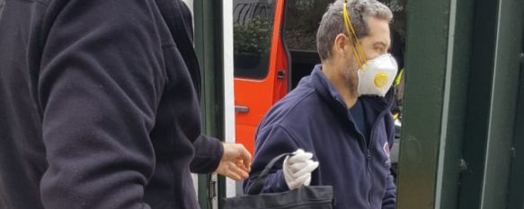 Uno de los miembros del Consorcio Provincial de Bomberos en Ronda participa en la entrega de equipos a las familias de alumnos sin recursos digitales junto con el vicedirector del centro. // Esther Márquez