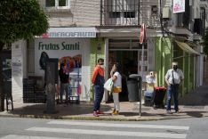 Los clientes de una frutería esperan en la calle su turno, al haber un aforo limitado que impide acceder al establecimiento a más de un cliente. // Juan Velasco