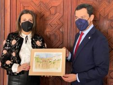 La alcaldesa de Ronda ha entregado al presidente de la Junta una lámina del Puente Nuevo, obra de la artista local Lola Lobato // CharryTV