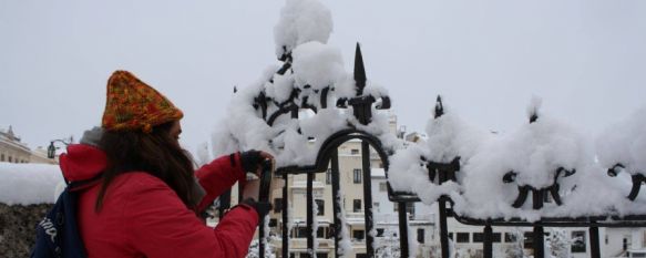 Una joven toma una fotografía en el Puente Nuevo durante la última gran nevada en Ronda // CharryTV