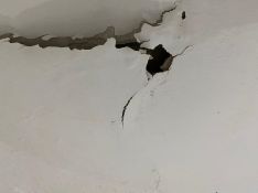 El techo del baño de uno de los residentes presenta este aspecto tras los destrozos del okupa, que vive en el piso de arriba. // Vecino afectado
