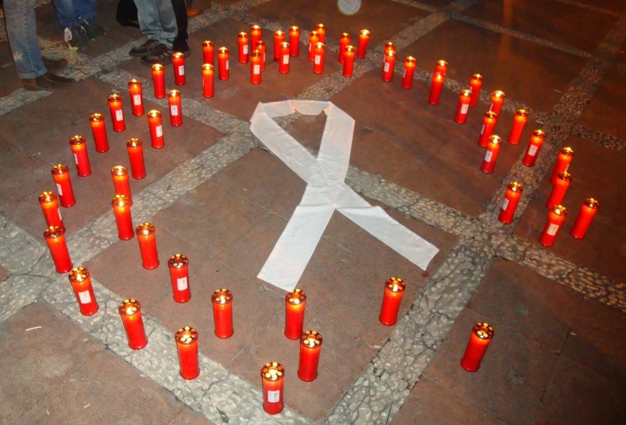 El lazo blanco, rodeado de velas en recuerdo de las víctimas de la violencia de género.
