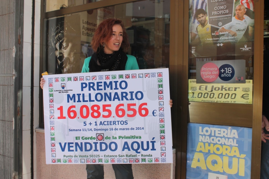 Inmaculada Racero muestra el cartel con el premio millonario.