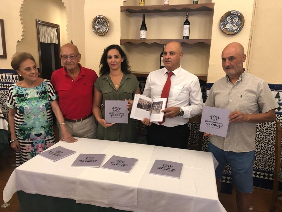Los miembros de la familia Flores muestran el ejemplar que recoge las anécdotas del restaurante desde sus inicios hasta el día de hoy.