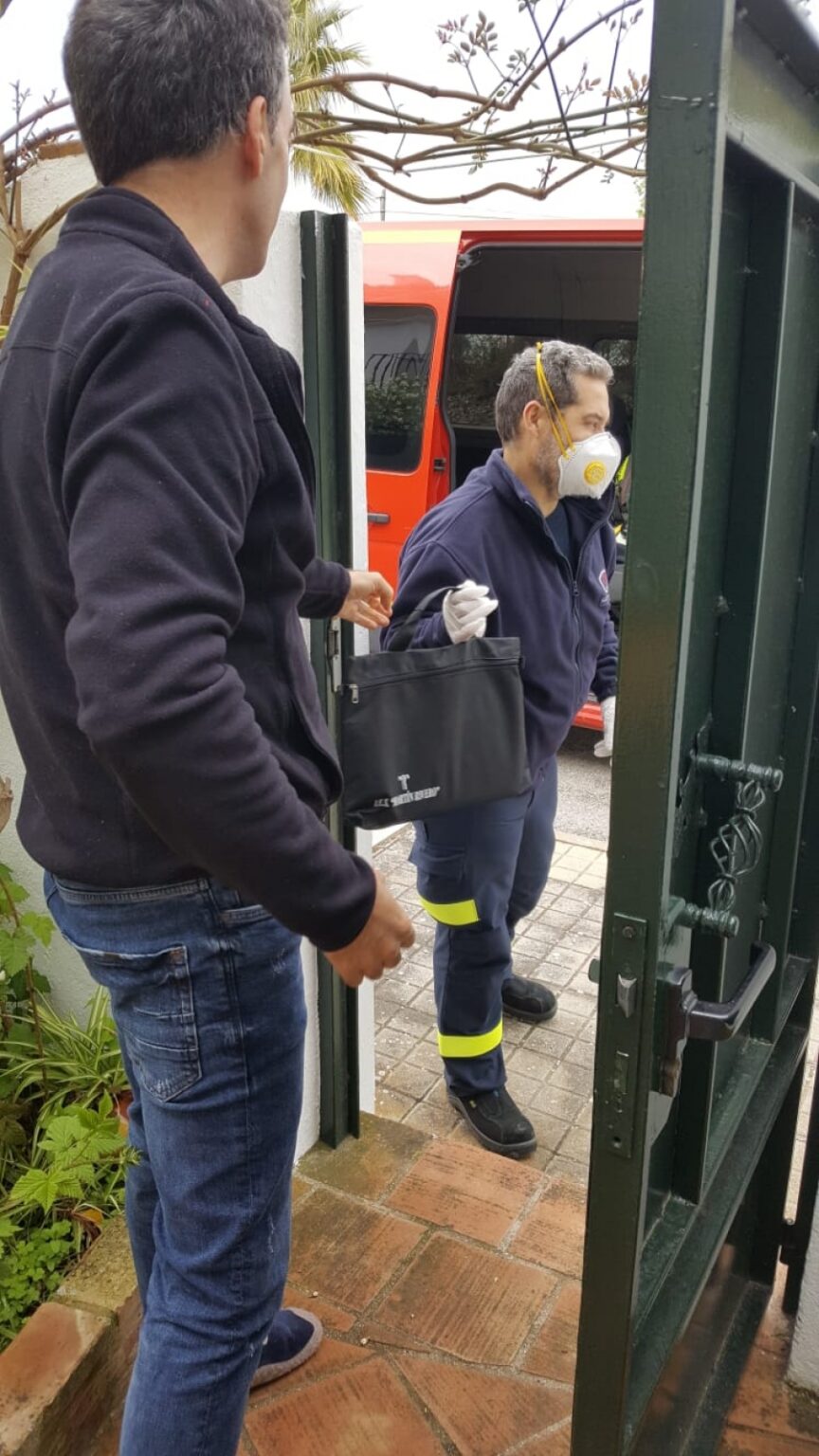 Uno de los miembros del Consorcio Provincial de Bomberos en Ronda participa en la entrega de equipos a las familias de alumnos sin recursos digitales junto con el vicedirector del centro.