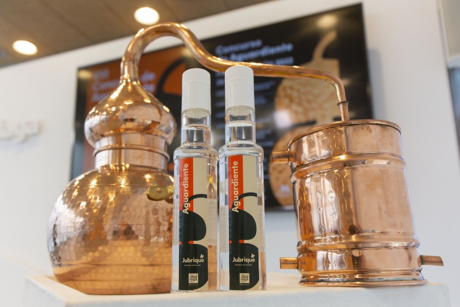 Un alambique y varias botellas del licor jubriqueño en la presentación del evento en la sede de la Diputación de Málaga