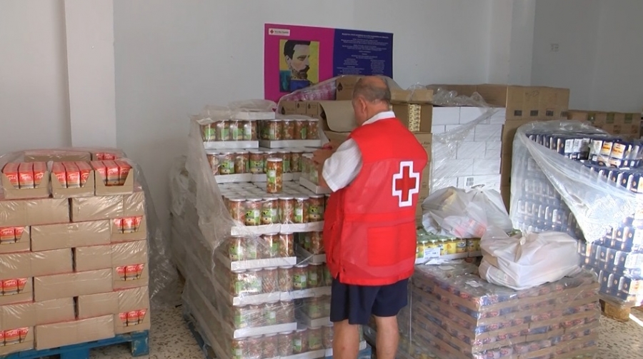 Un voluntario de Cruz Roja junto a los alimentos que se han repartido.