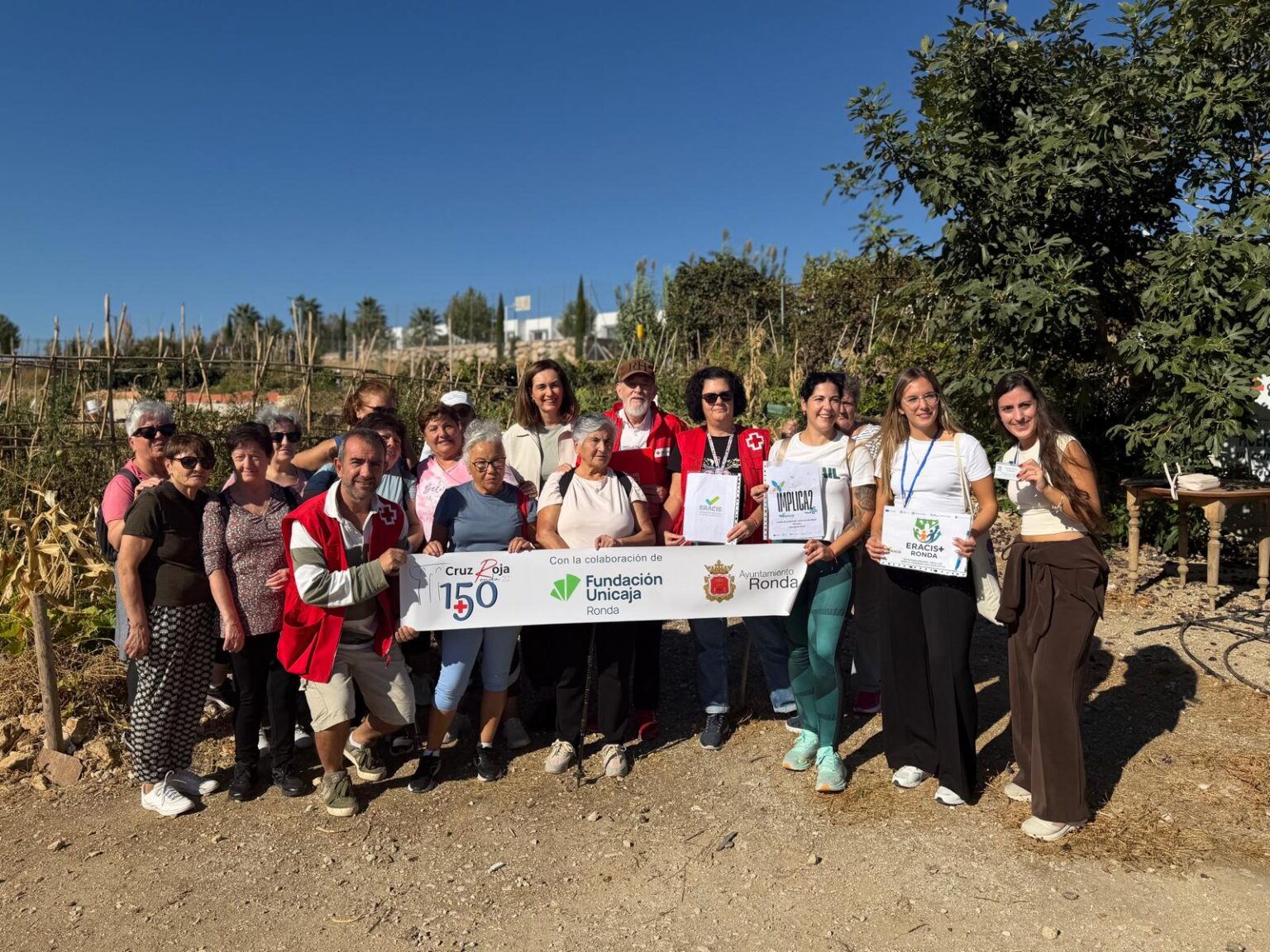 Foto de familia en los huertos sociales ecológicos de Cruz Roja