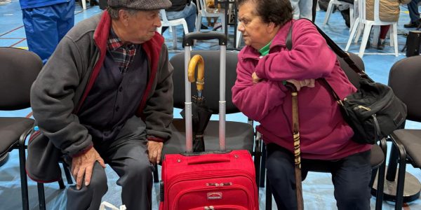 Una pareja de avanzada edad, junto a sus maletas