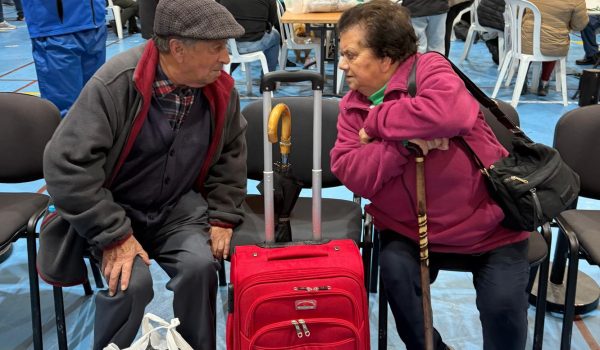 Una pareja de avanzada edad, junto a sus maletas