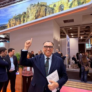Arturo Bernal, consejero de Turismo, posa frente a una imagen del Puente Nuevo en el Messe Berlín
