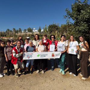 Foto de familia en los huertos sociales ecológicos de Cruz Roja