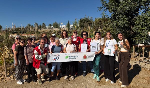 Foto de familia en los huertos sociales ecológicos de Cruz Roja