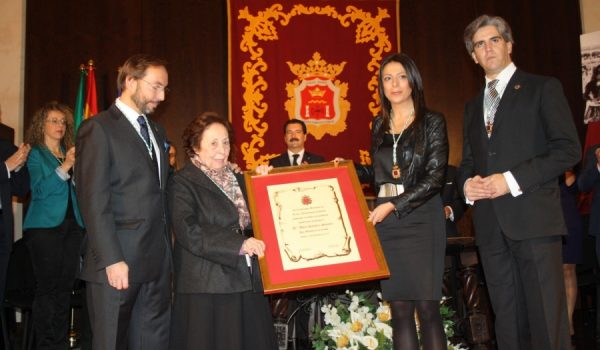 Adela Ramírez recogiendo el reconocimiento que la convierte en Hija Adoptiva.