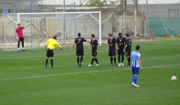 El local Jurado se dispone a lanzar un golpe franco ante la atenta mirada de Caballero.