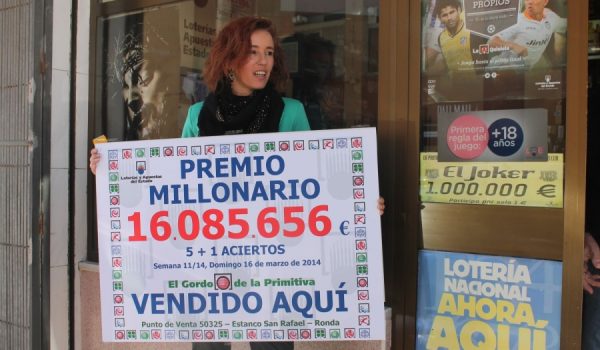 Inmaculada Racero muestra el cartel con el premio millonario.