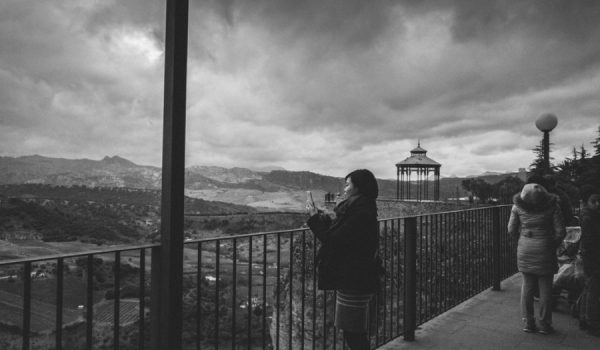 Imagen de una turista oriental realizando una fotografía con su teléfono móvil.