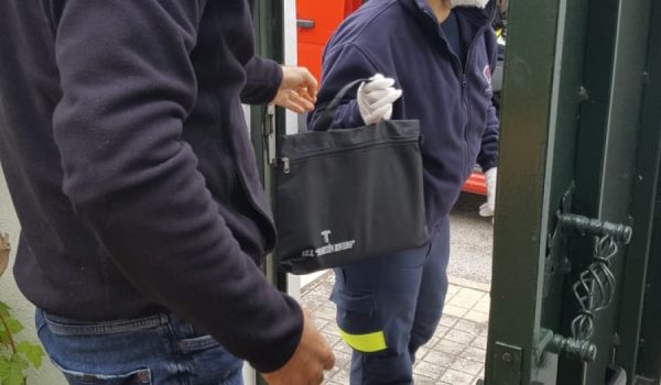 Uno de los miembros del Consorcio Provincial de Bomberos en Ronda participa en la entrega de equipos a las familias de alumnos sin recursos digitales junto con el vicedirector del centro.