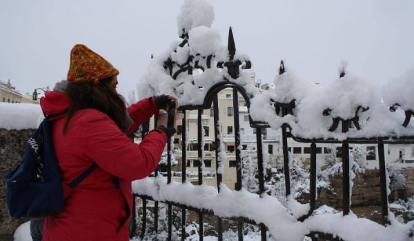 Una joven toma una fotografía en el Puente Nuevo durante la última gran nevada en Ronda