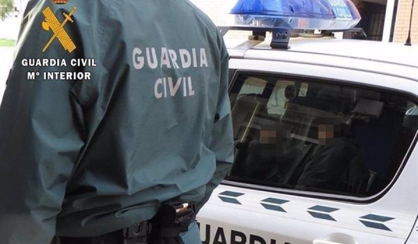 Un agente de la Guardia Civil junto a un coche patrulla