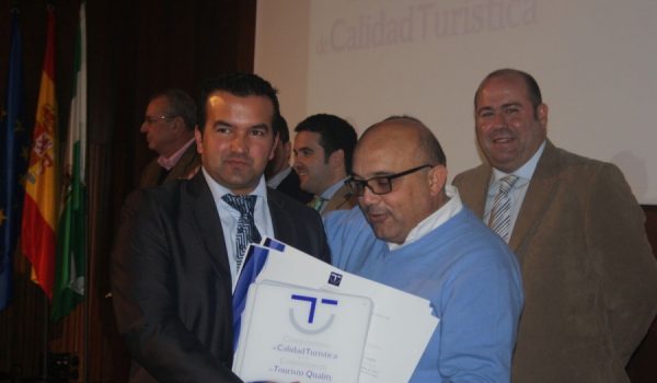 Sergio Sedeño, gerente de Turismo de Ronda S.A., recibe uno de los distintivos de manos del concejal Jesús Vázquez.