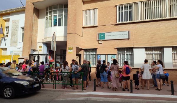 Menores de Primaria esperan junto a sus padres y abuelos en la puerta del CEIP Vicente Espinel para entrar de nuevo en las clases de manera escalonada