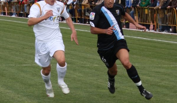 Comitre, intentando frenar una internada del malaguista Adán.