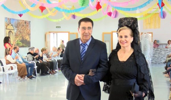 Una de las mujeres participantes en el desfile de mantillas con su acompañante.