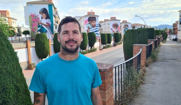 Kato posa para Canal Charry TV con sus murales detrás.