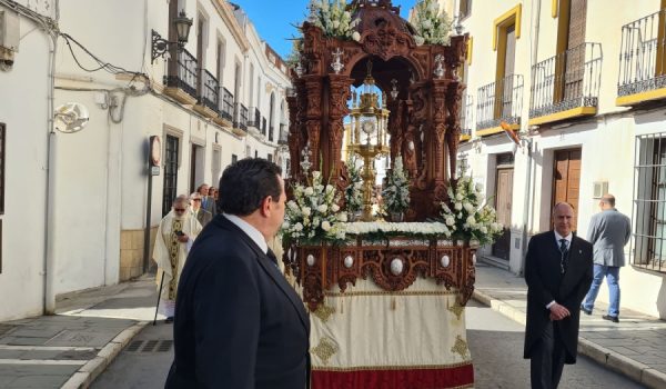 El baldaquino con el Santísimo a su paso la calle Armiñán.