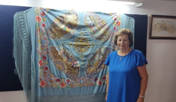 Rosario Solís junto a un mantón costumbrista, con cuadros de Goya bordados