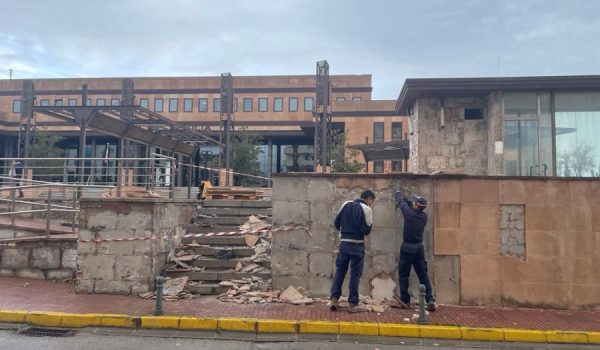 Dos trabajadores municipales en uno de los laterales exteriores de la plaza.