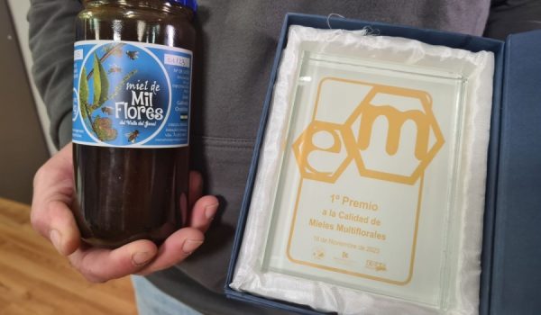 Galindo muestra un tarro de su miel, que se puede adquirir en Ronda en Casa Don Curro, y el premio.