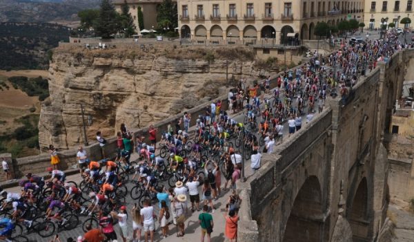 El pelotón a su paso por el Puente Nuevo durante la salida neutralizada de la etapa 13, Ronda-Montilla, el 2 de septiembre de 2022.