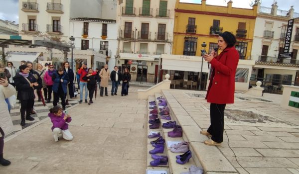 Una niña con chaqueta morada graba con el móvil a la presidenta de Rondafem mientras lee un manifiesto.