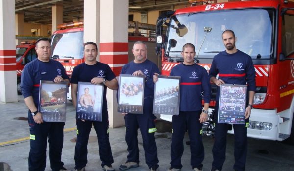 Un grupo de bomberos, posando con un ejemplar del calendario.