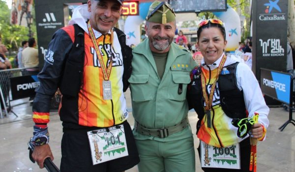 El coronel Paúl, junto a dos de los marchadores que alcanzaron la línea de meta el domingo por la mañana