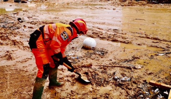 Uno de los voluntarios retira barro de la vía pública.