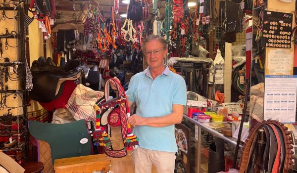 El talabartero posa con la pieza más valiosa, un aparejo con confeccionó junto a sus padres y que usó su hijo en una feria de Pedro Romero.