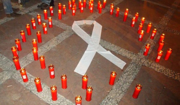 El lazo blanco, rodeado de velas en recuerdo de las víctimas de la violencia de género.